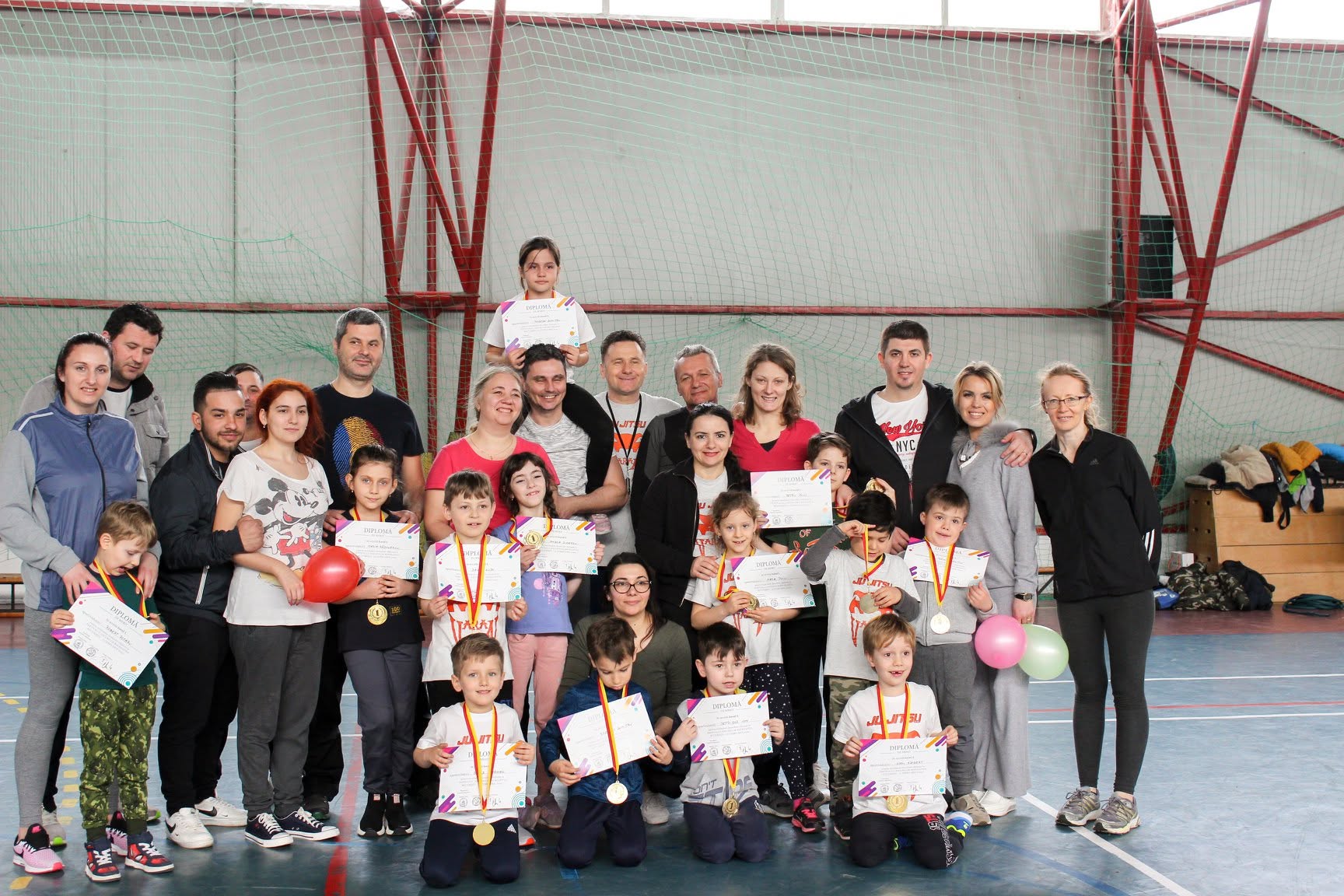 Copiii clubului cu diplome și medalii, alături de părinți, după o competiție